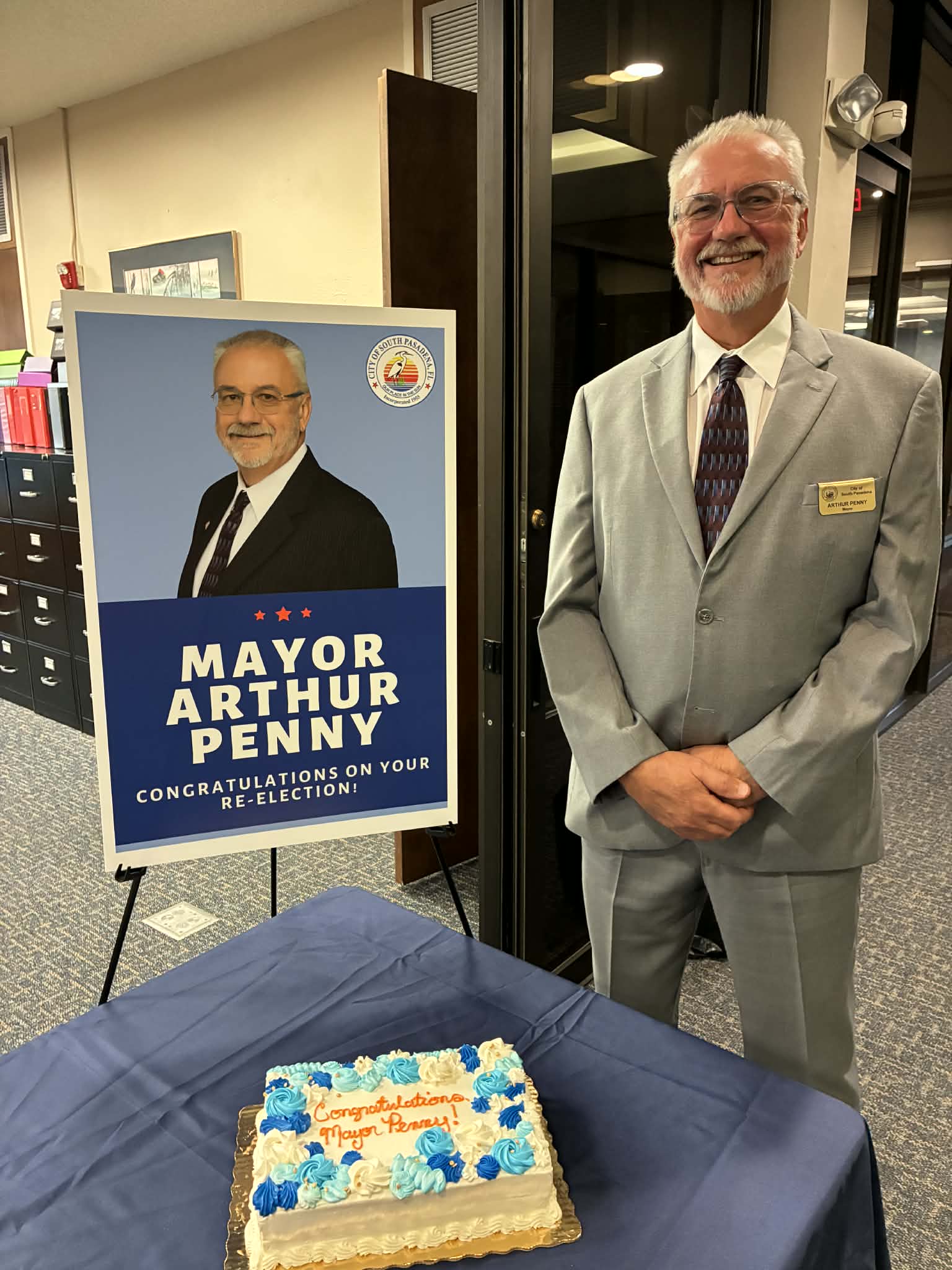 Mayor Penny Swearing In- Standing by his cake and poster.